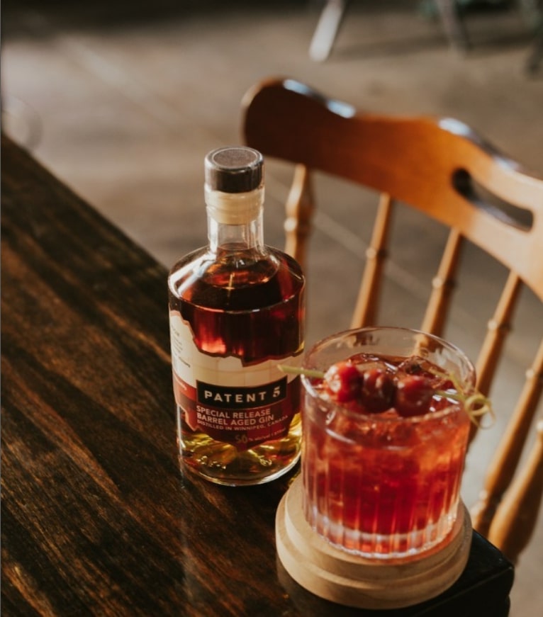 A bottle of gin and a cocktail in Patent 5 Distillery and Tasting Room Winnipeg